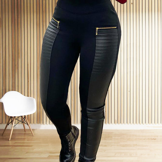 Black leggings with leather patches and gold zippers worn by a person indoors.