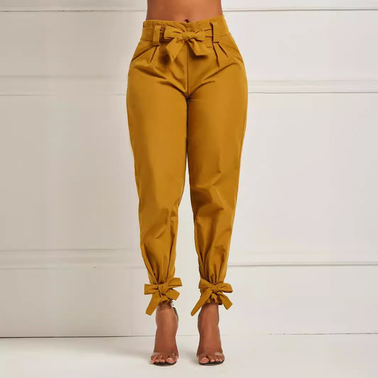 Mustard yellow pants with tied cuffs and waistband on a white background